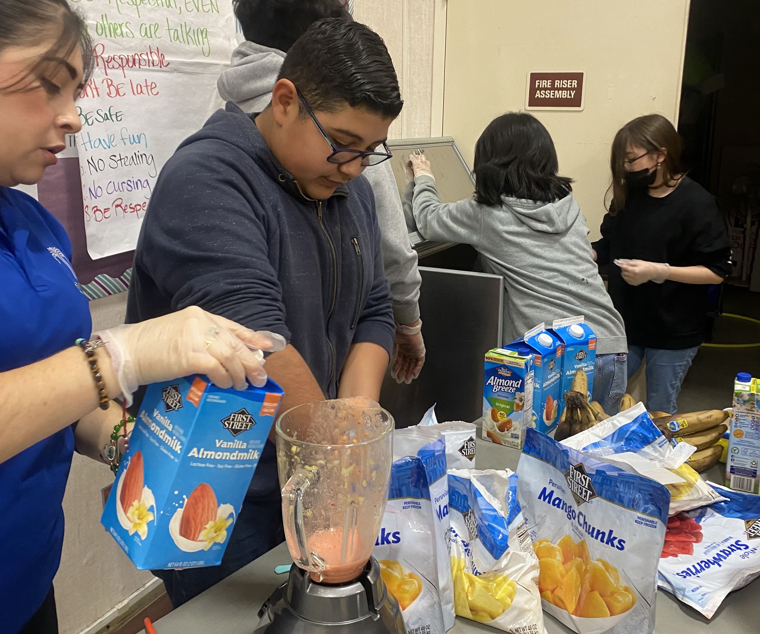 FELP staff making smoothie with students